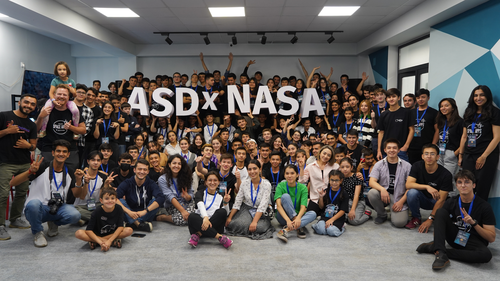 Large group image of Space Apps participants holding a sign