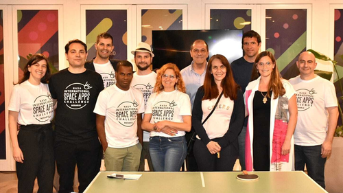 Group of Space Apps participants standing next to each other with Space Apps t-shirts