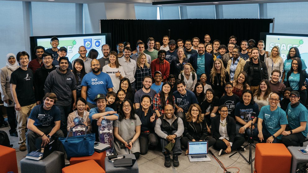 Large group of diverse people of ages in frame for a group picture at a Space Apps event